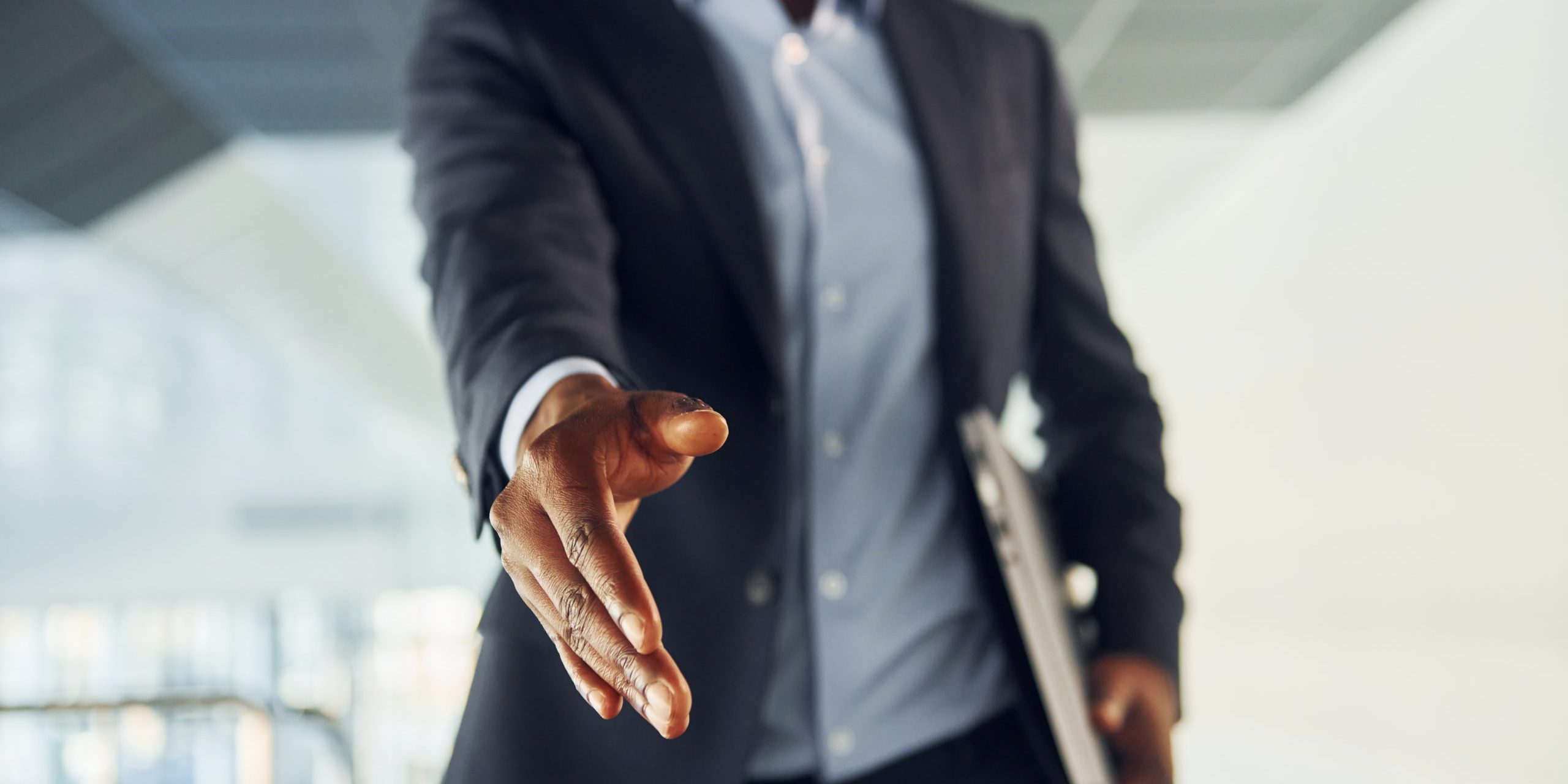 Successfull agreement. Young african american businessman in black suit is indoors